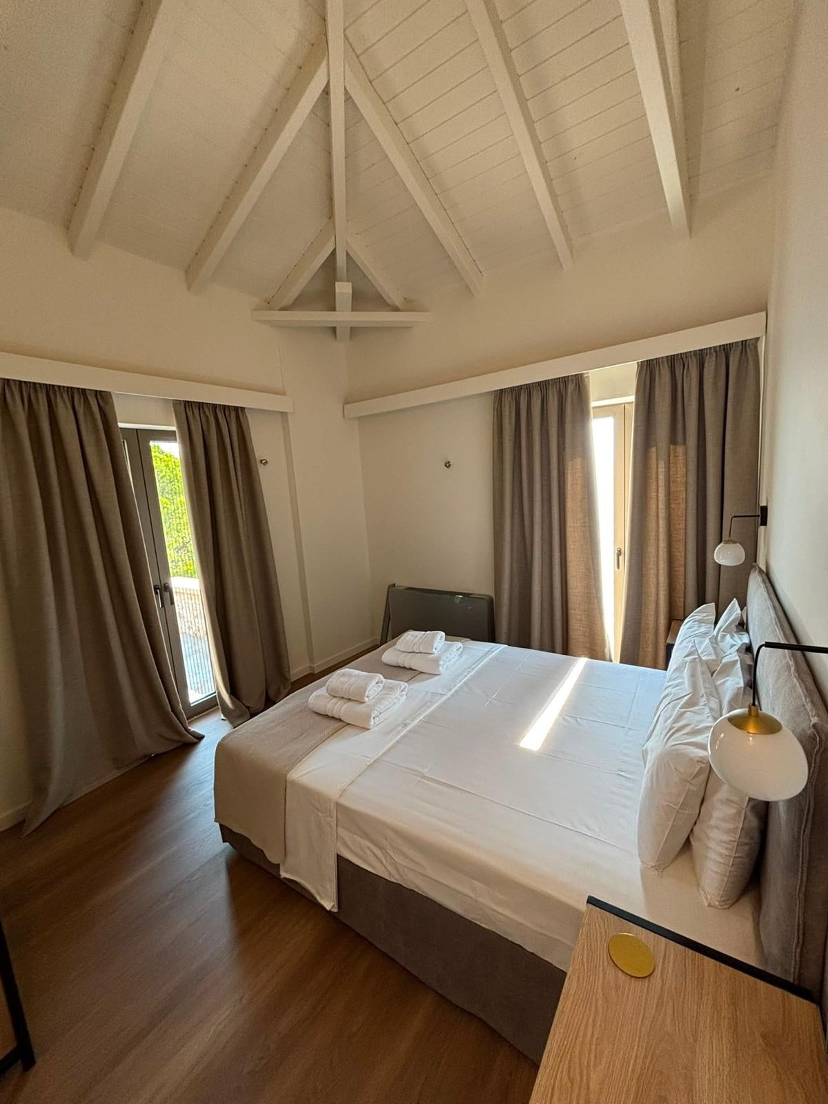 A bedroom under the pitched beams of the upper floor.